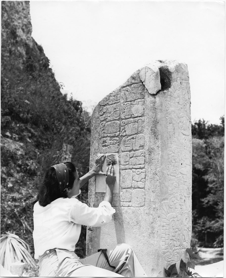 Students undergoing archaeological training taking rubbing of Maya hieroglyph, 1961 (Tikal, Guatemala)